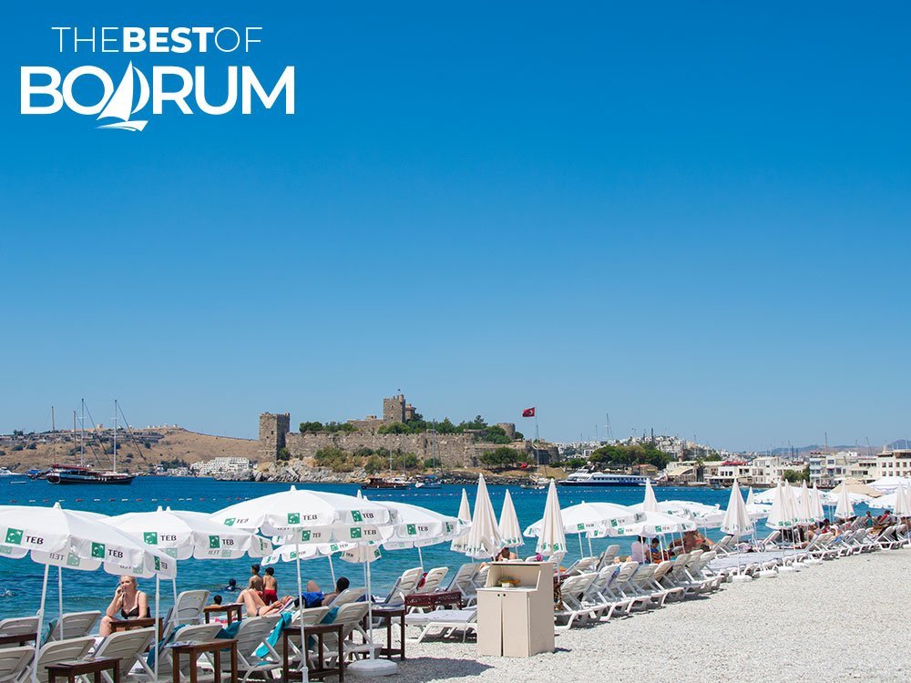Coastline of Bodrum bar street with beach access and clear sea, showing the urban side of beaches in Bodrum.