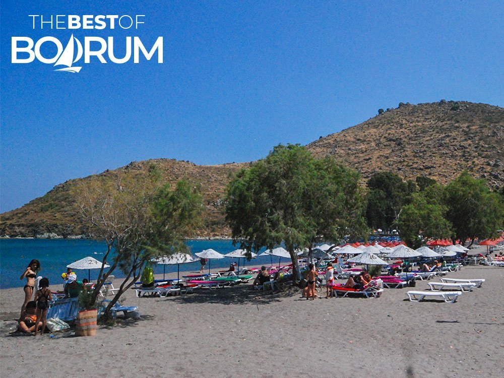 Karaincir Beach with people swimming and sunbathing, one of the most family-friendly beaches in Bodrum.