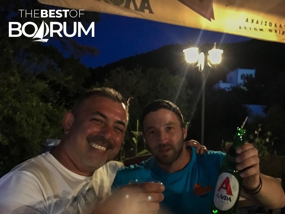 Two travellers sharing a drink with a local friend during an island stop near Bodrum.