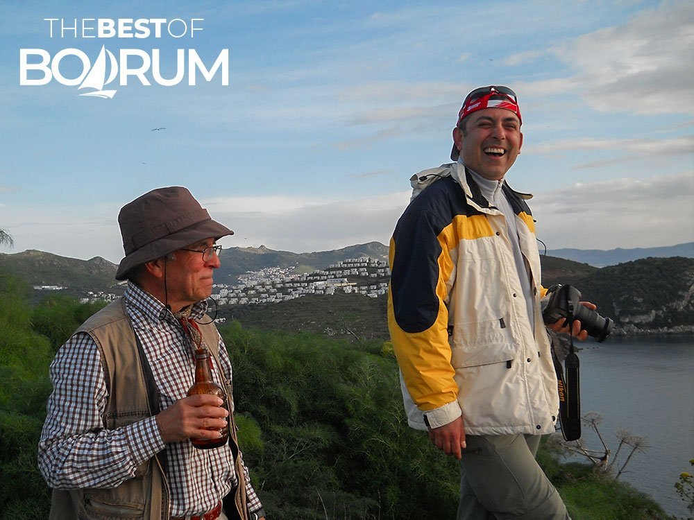 Two friends smiling on Babadag Hill in Gümüşlük with Bodrum’s landscape in the background.
