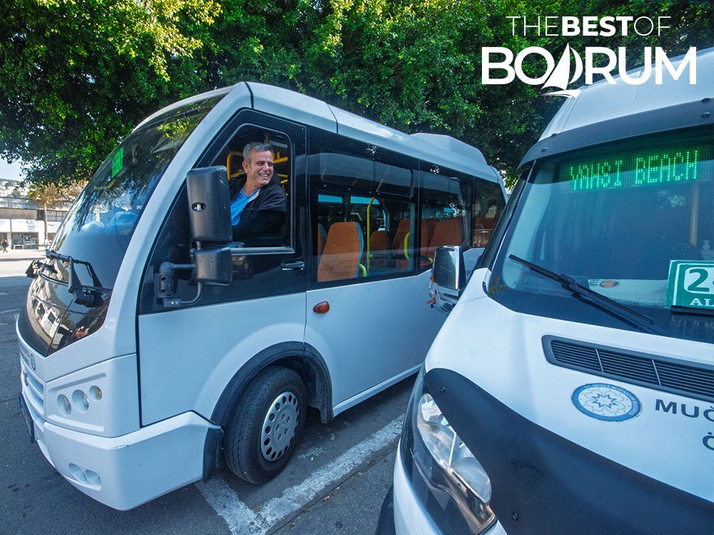 A smiling minibus driver in Bodrum waiting at the terminal before starting the route to Yahşi Beach.
