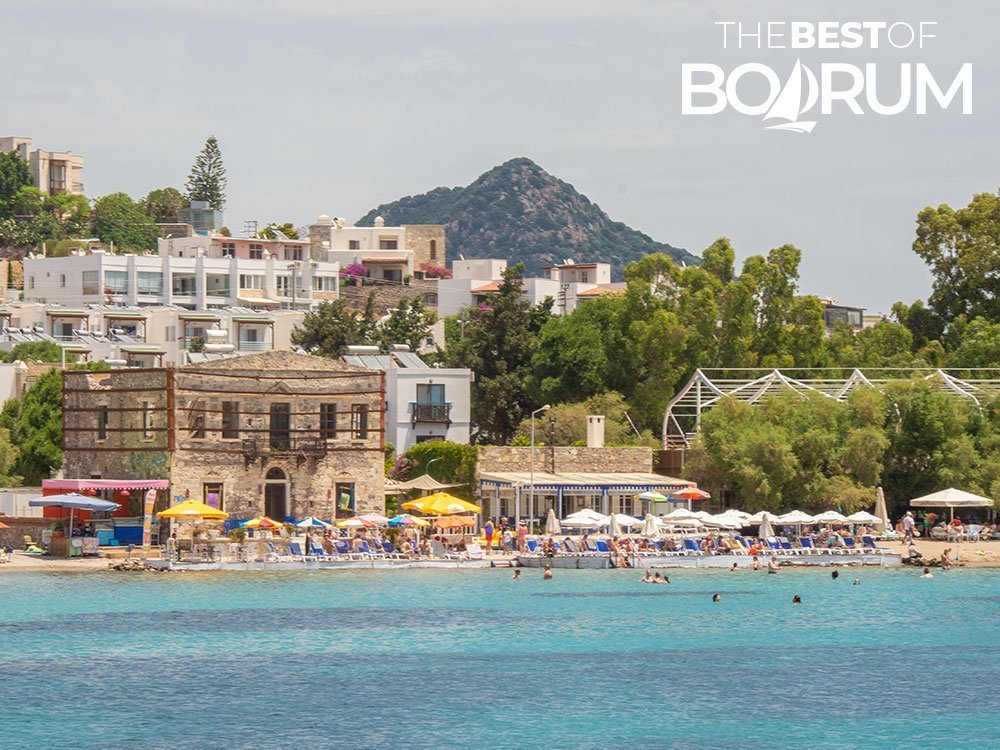 Clear turquoise water and a small beach with sunbeds and umbrellas at Akyarlar on the Bodrum Peninsula.